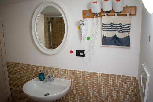 a bathroom with a sink and a mirror at Abbey Hostel in Genoa