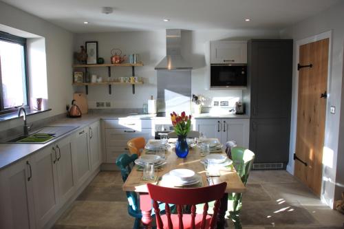 a kitchen with a wooden table with chairs and a dining room at Charming and luxury retreats on our farm in Billingshurst