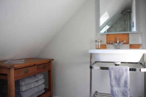 a bathroom with a sink and a pile of towels at Charming and luxury retreats on our farm in Billingshurst