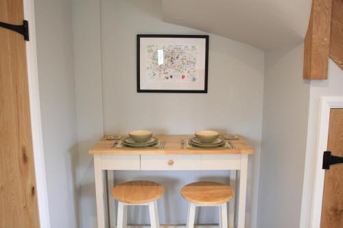 a small table with two stools in a room at Charming and luxury retreats on our farm in Billingshurst