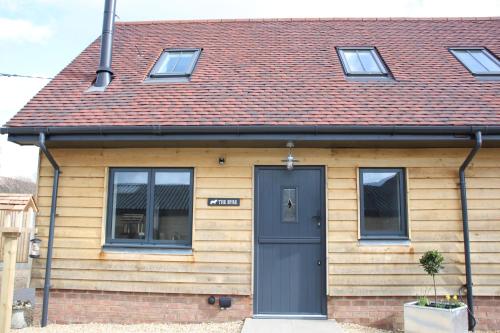 a house with a blue door and a red roof at Charming and luxury retreats on our farm in Billingshurst