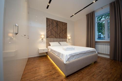 a bedroom with a large white bed and a window at Современный минимализм в центре Киева. in Kyiv