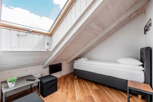 a bedroom with a bed and a desk and a window at Small attic rooms in Kaunas old town in Kaunas
