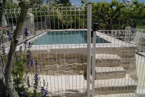 une porte menant à une piscine dans un jardin dans l'établissement Gîte en Provence ''Rose'', à Modène