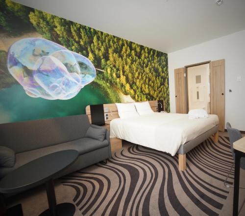 a bedroom with a bed and a couch and a painting at Novotel Vilnius Centre in Vilnius
