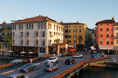 a busy city street with cars parked on a bridge at Hotel Bell'arrivo by Dori in Peschiera del Garda
