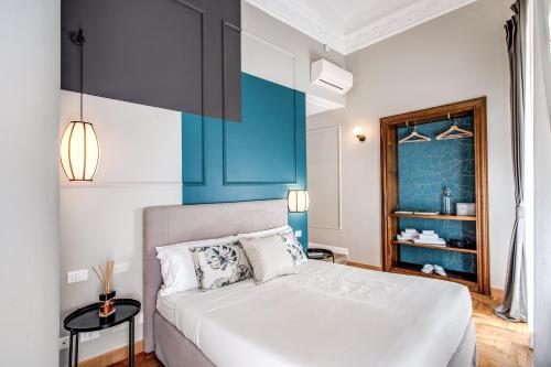 a bedroom with a white bed and a blue wall at Trevispagna Charme in Rome