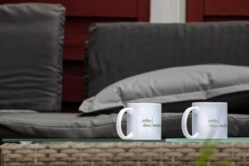 two coffee mugs sitting on a table in front of a couch at Panorama Lodge Hohegeiß Sport und Erholung im Harz in Braunlage