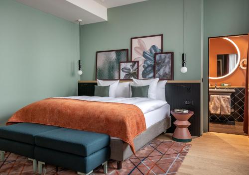 チューリッヒにあるSorell Hotel St. Peterのベッドルーム(大型ベッド1台付)、バスルームが備わります。