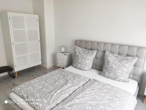 a bedroom with a bed with a gray headboard and pillows at Ferienwohnungen Wilhelmshöher Allee in Kassel