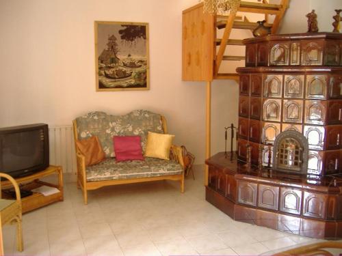 a living room with a chair and a tv at Anna Üdülőház in Balatonberény