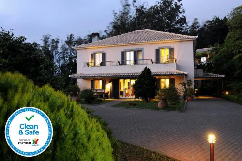 a house with a sign that says clean and safe at Quinta Da Cova Do Milho in Santo António da Serra