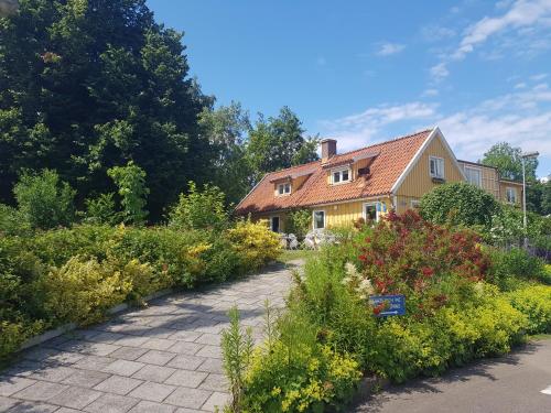 a yellow house with a garden in front of it at Nyckelbo Vandrarhem in Helsingborg