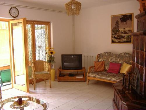 a living room with a couch and a tv at Anna Üdülőház in Balatonberény