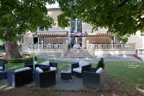a group of chairs sitting in the yard of a house at Hôtel Restaurant du Château de la Tour in Béguey