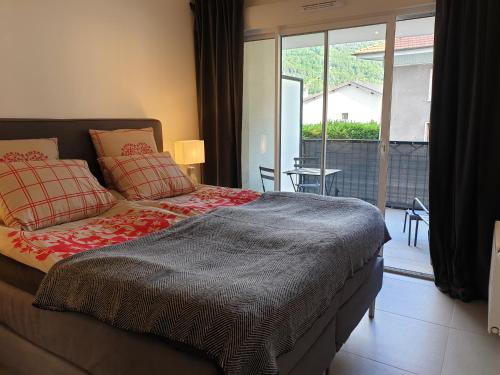 a bedroom with a bed and a sliding glass door at Les Campanules in Bourg-Saint-Maurice