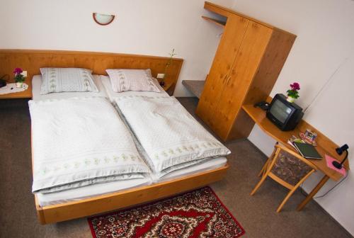 1 Schlafzimmer mit 2 Betten, einem Schreibtisch und einem TV in der Unterkunft Landgasthof Kemter in Dröbischau
