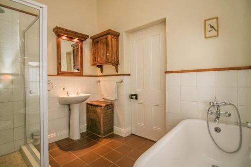łazienka z wanną i umywalką w obiekcie 54 on Middle - Solar-powered stay w mieście Graaff-Reinet