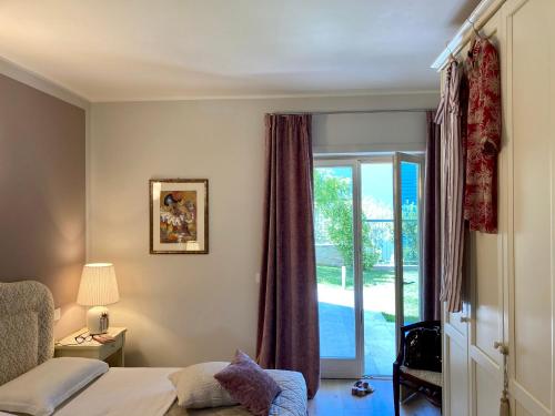 トッリ・デル・ベーナコにあるCasa Veronesiのベッドルーム1室(ベッド1台付)、スライド式ガラスドアが備わります。