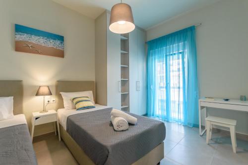 a bedroom with two beds and a window at Seashell Apt 2 in Stalida