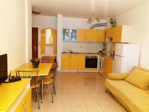 a kitchen and a living room with yellow cabinets at Lazur 1-5 Apartments Complex in Sveti Vlas