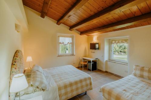 a bedroom with two beds and a table and a window at Alle Pendici del Conero in Sirolo
