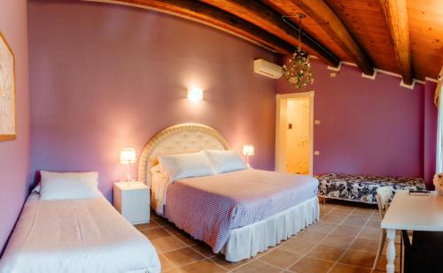 two beds in a room with purple walls at Alle Pendici del Conero in Sirolo