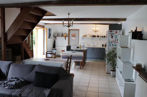 a living room with a couch and a kitchen at Chambres d'hôtes Chez Barbara in Tardets-Sorholus