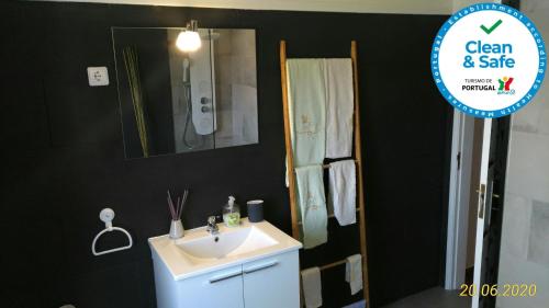 ein Badezimmer mit einem weißen Waschbecken und einem Spiegel in der Unterkunft Sailor´s House in Carvoeira