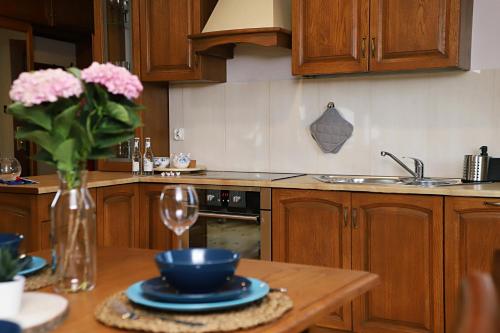 una cocina con una mesa con un jarrón de flores rosas en Apartament Kaszubska Sielanka, en Kartuzy