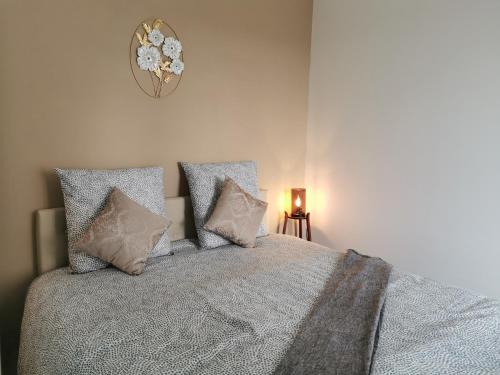 - une chambre avec un lit avec des oreillers et une horloge murale dans l'établissement Les appartements du Marché, à Dinan