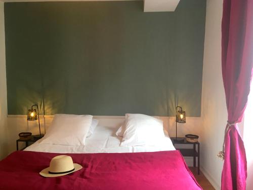 une chambre avec un lit avec un chapeau dessus dans l'établissement Hôtel de Ville 2 avec Parking, à La Rochelle