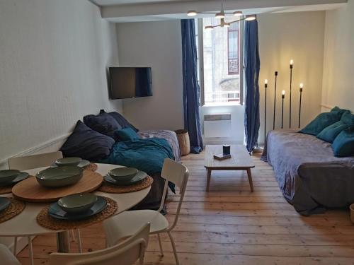 un salon avec un canapé et une table dans l'établissement Hôtel de Ville 2 avec Parking, à La Rochelle