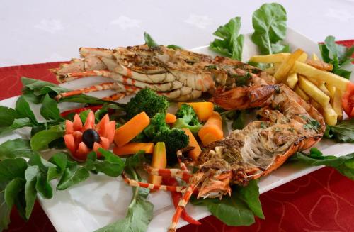 a plate of food with fish and vegetables and french fries at Beyt Al Salaam in Zanzibar City