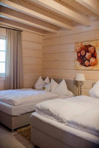 two beds in a room with wooden walls at Chalet Bischofsmühle in Helmbrechts
