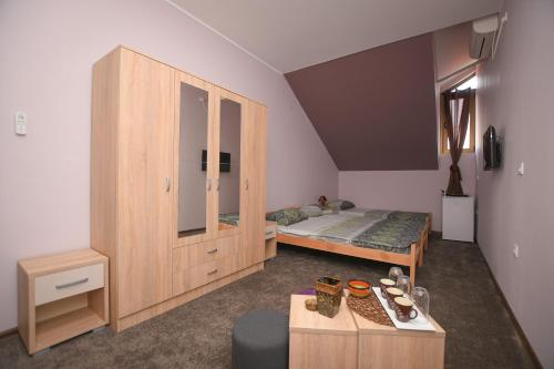 a bedroom with a bed and a wooden cabinet at Apartmani Genčić 3 in Kladovo