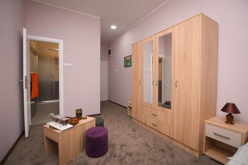 a bedroom with a wooden cabinet and a table at Apartmani Genčić 3 in Kladovo