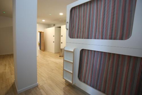 a hallway with a red and white striped wall at dpaso Urban Hostel in Pontevedra