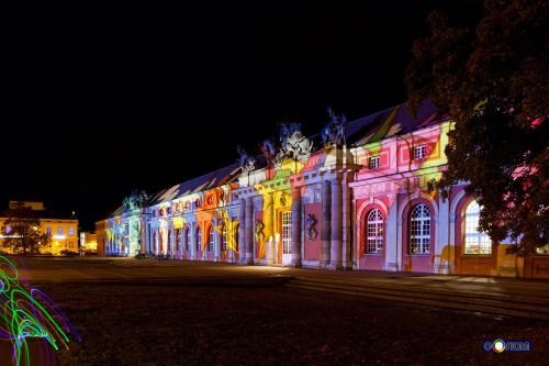 a building lit up with colorful lights at night at Mercure Hotel Potsdam City in Potsdam