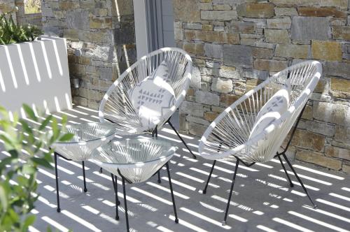 three chairs and a table on a patio at Oro Suites in Kinion