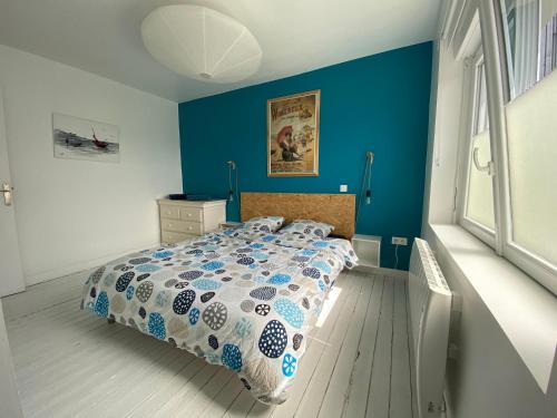 ヴィムルーにあるLe Réservoirの青い壁のベッドルーム1室(ベッド1台付)