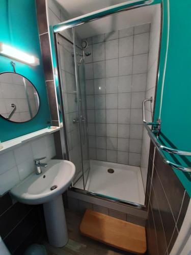 a bathroom with a shower and a sink and a mirror at Come Inn in Neufchâtel-en-Bray