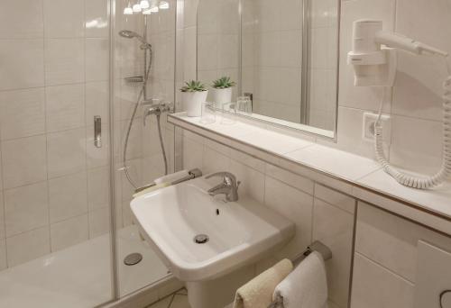 a white bathroom with a sink and a shower at Gästehaus Kramer - Emde in Willingen
