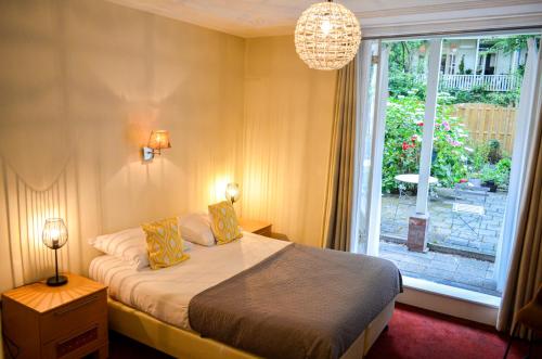a bedroom with a bed and a large window at Family Hotel Kooyk in Amsterdam