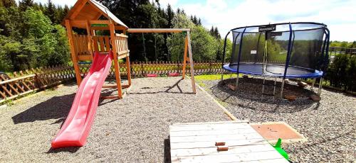a playground with a red slide and a cage at Penzion Studánka, Klíny in Klíny