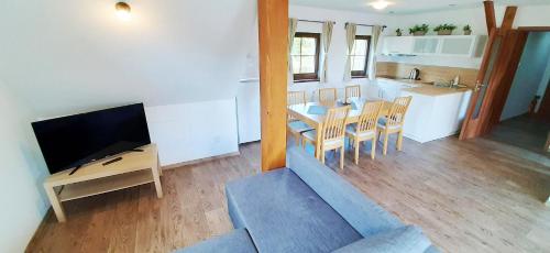 a living room with a couch and a table and a kitchen at Penzion Studánka, Klíny in Klíny