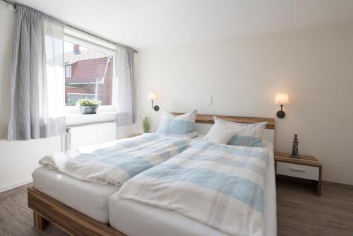 two beds in a bedroom with a window at Krögerhof in Manhagen