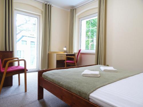 una camera con un letto e due sedie e una finestra di Nowa Fregata - pokoje nad morzem a Jastrzębia Góra
