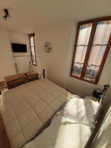 une chambre avec un grand lit et deux fenêtres dans l'établissement MAISON 100 M2, Terrasse 25 m2, Clim, 3 chbs avec tv, parking, à Pierrelatte