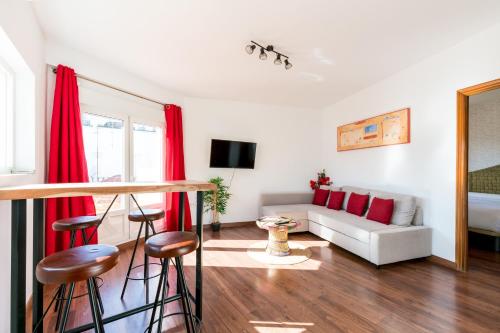 ein Wohnzimmer mit roten Vorhängen und einer weißen Couch in der Unterkunft Constitución Terraza Olehousing in Sevilla